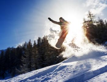 snowboarder making jump on mountain